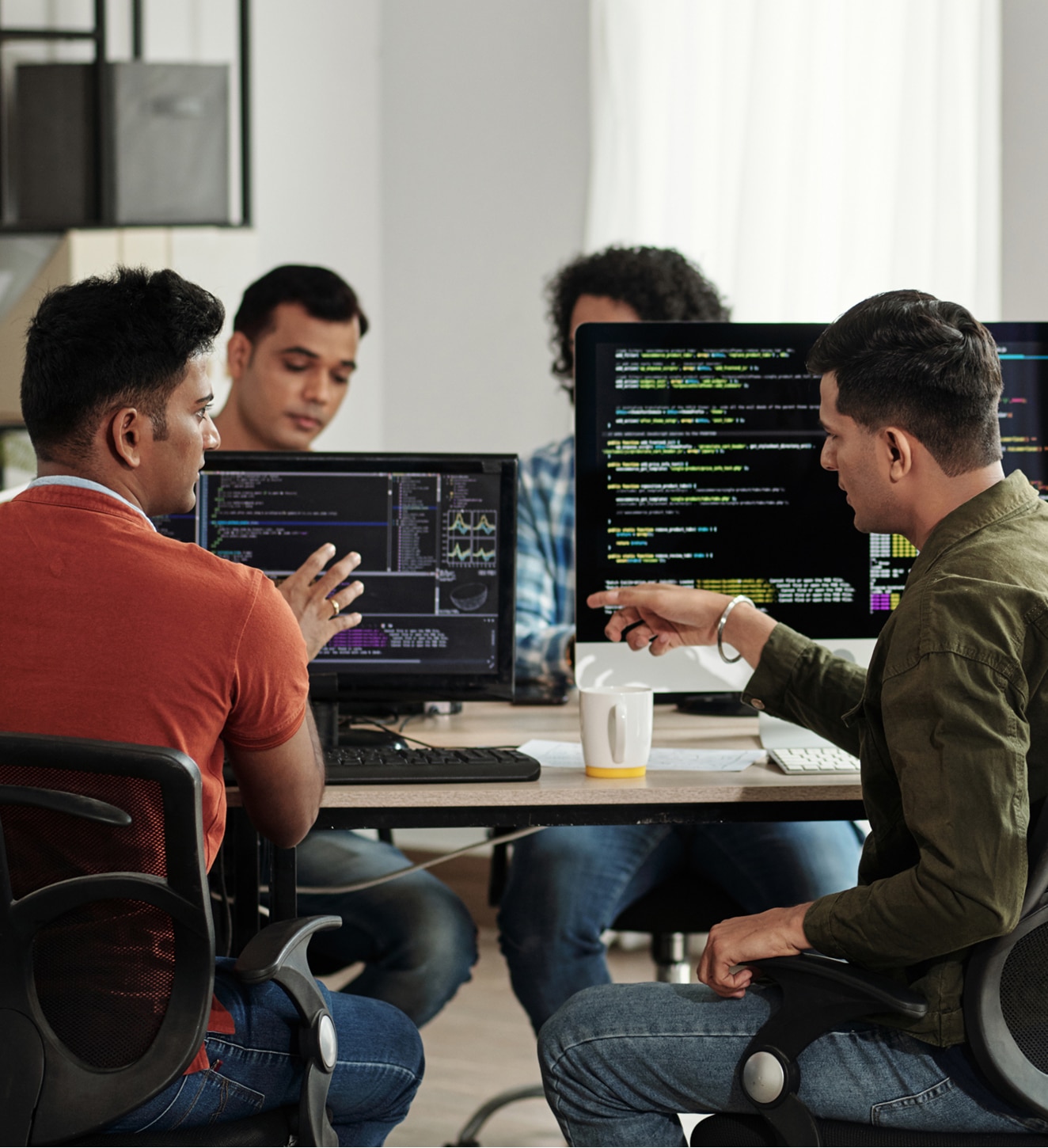 Programmers sitting at desks working on custom software development.