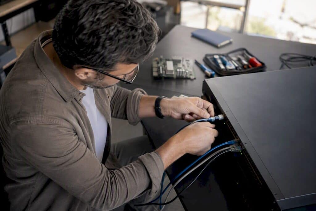 Engineer connecting cable to network switch