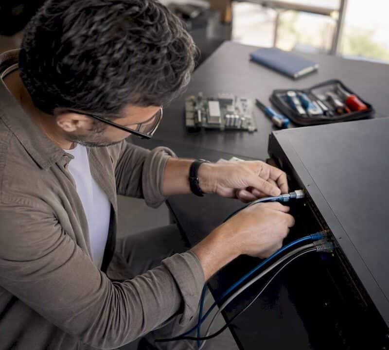 Engineer connecting cable to network switch